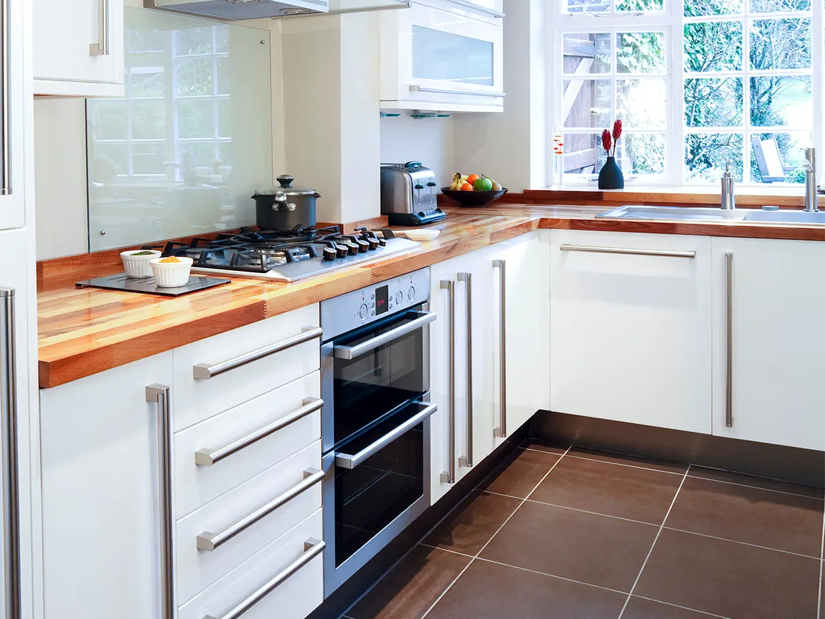 basic kitchen remodeling with wooden counterstops and white cabinets with chrome hardware