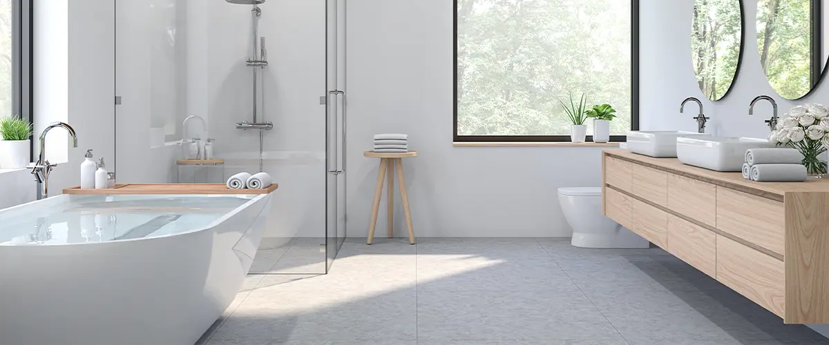 White bathroom with bathtub and wood cabinet.