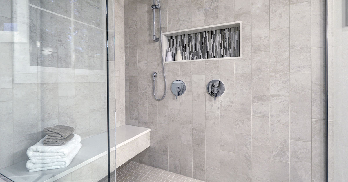 Modern shower with sleek bathroom walls and neatly folded towels.