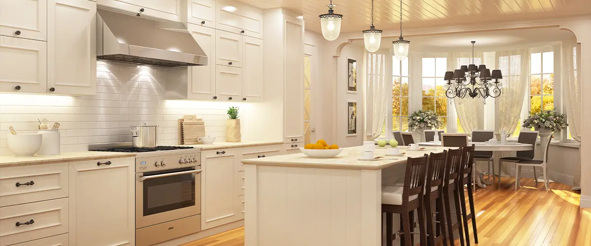 Bright luxury kitchen with white cabinets, stainless steel appliances, and open dining area featuring hardwood floors.