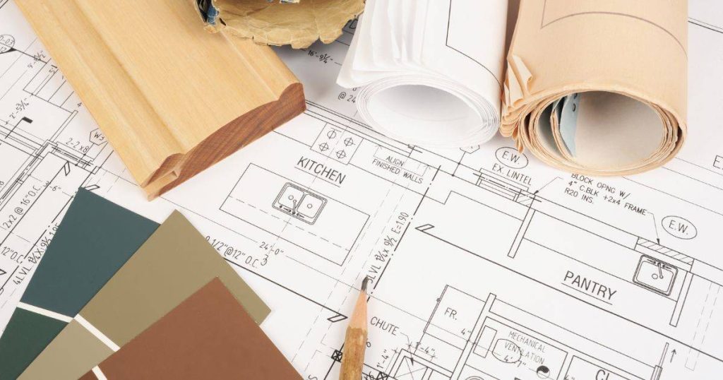 Architectural blueprints and home design plans with a pencil and ruler on top.