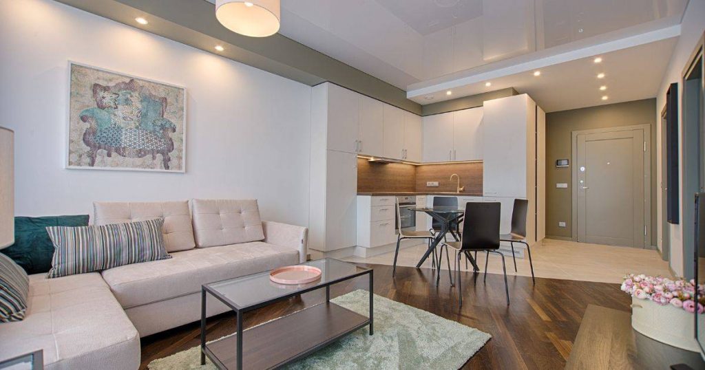 A modern open-concept living and dining area with a neutral color palette and contemporary furniture.