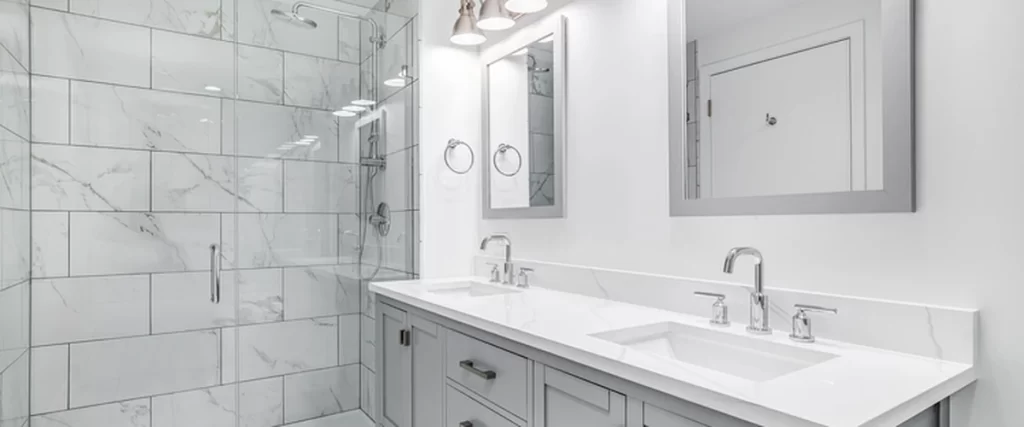 Shower insert vs tiled shower comparison in a professional bathroom with marble tiled shower walls, glass enclosure, dual-sink vanity, chrome fixtures, and elegant lighting